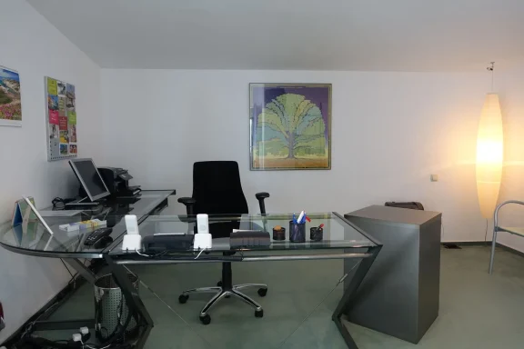 Schreibtisch aus Glas mit einer Sitzgelegenheit für Bürotätigkeiten